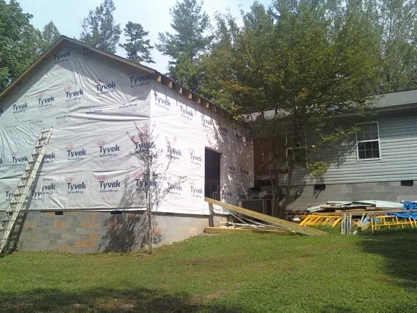 Tyvek wrapped gable on a new room addition beside an existing home in Marrero
