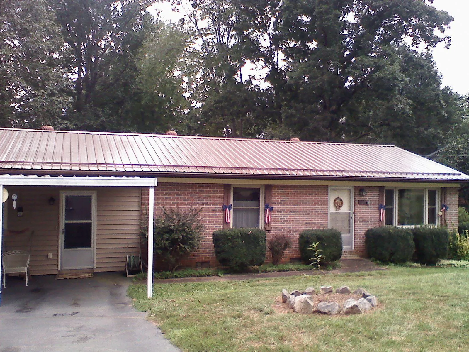 Bronze metal roof and carport on a brick ranch home — Roof Repair work by our crew in Marrero