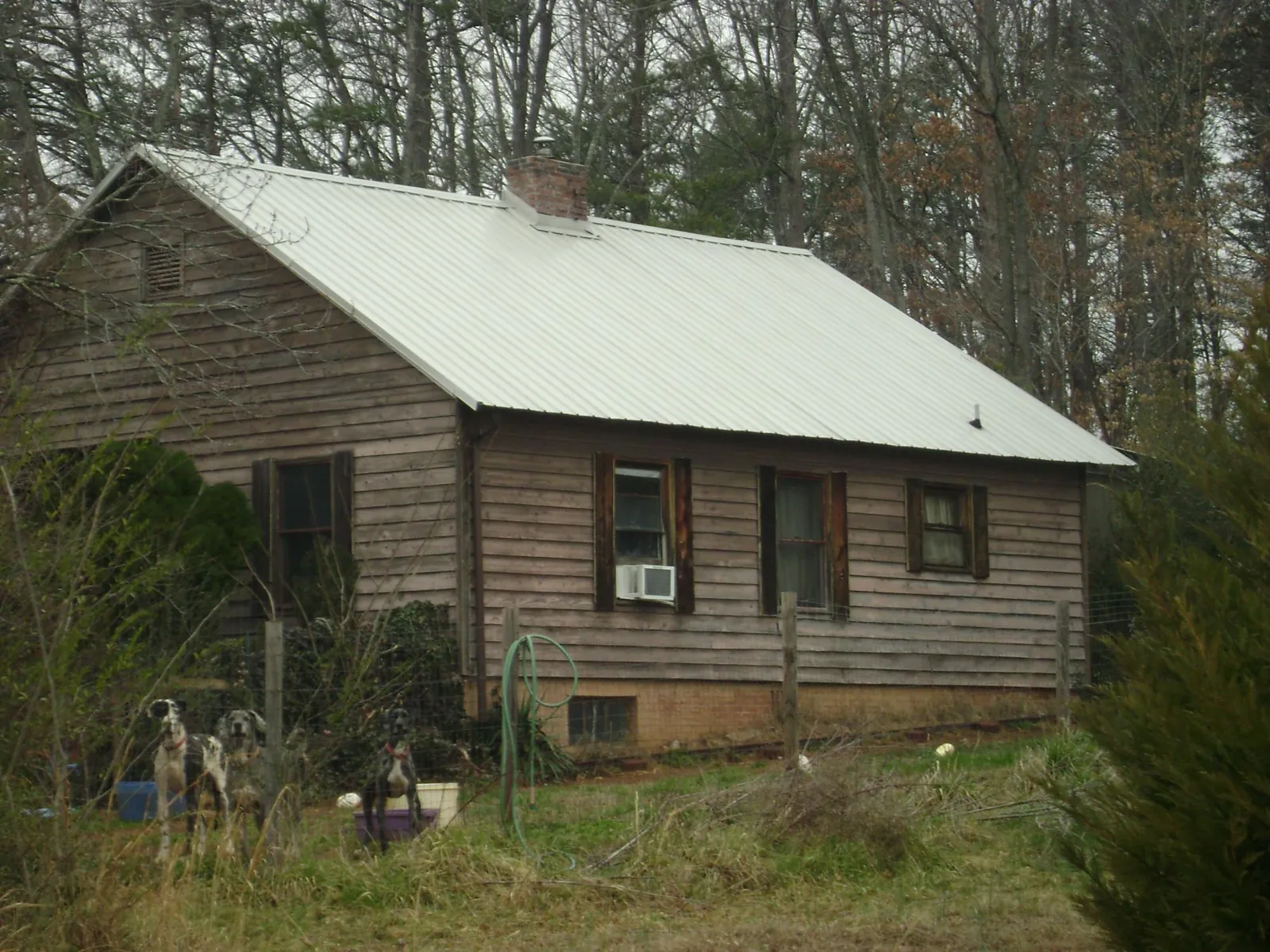 White metal roof on an old wood sided farmhouse, from a Metal Roof Installation job in Marrero